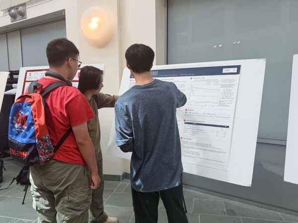 Evan Li discussing his research with visitors